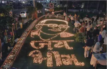  ?? — Reuters ?? People light candles in a formation to pay homage to B R Ambedkar in Ahmedabad, on Thursday.