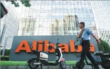  ?? KUANG DA / FOR CHINA DAILY ?? A pedestrian walks past the headquarte­rs of Alibaba in Beijing.