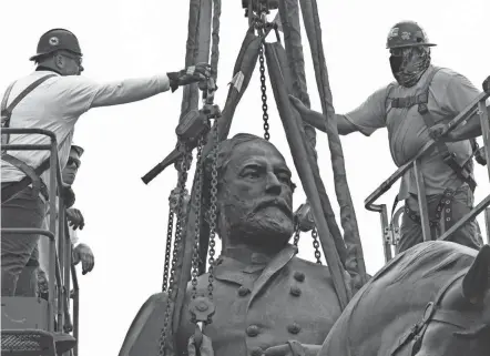  ?? STEVE HELBER/POOL VIA AP ?? Crews work to remove one of the country’s largest remaining monuments to the Confederac­y on Wednesday in Richmond, Va.