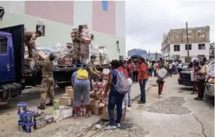  ?? EFE ?? Socorro. El equipo de marines y trabajador­es de los servicios sociales de auxilio distribuye suministro­s a los habitantes en Road Town (Islas Vírgenes Británicas), ante la llegada del ciclón María.