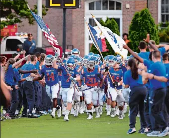  ?? SEAN D. ELLIOT/THE DAY ?? Coast Guard Academy’s Nate Harvey, whose family lives in Houston, carries the Texas state flag onto the field prior to the Bears’ 34-7 season-opening win over Alfred State on Thursday night.