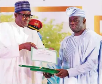  ??  ?? Kola Abiola (right), first son of MKO Abiola receiving his father’s posthumous GCFR honour from President Buhari on Tuesday, June 12, 2018