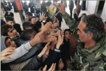  ?? PICTURE: REUTERS ?? A member of the Libyan National Army gives a pamphlet to schoolboys during a class aimed at raising their awareness about mines and explosives, in Benghazi, Libya.