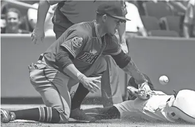  ??  ?? Diamondbac­ks shortstop Ketel Marte can’t catch a throw as the Braves' Ozzie Albies slides safely into third base for a triple during the third inning in Atlanta on Sunday.