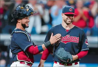  ?? RON SCHWANE/AP PHOTO ?? Cleveland Indians pitcher Corey Kluber, right, and catcher Yan Gomes celebrate a 2-0 win over the Detroit Tigers on Sept. 12 at Cleveland.