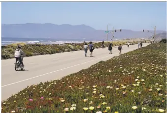  ?? Eric Risberg / Associated Press ?? People make their way along the carfree upper Great Highway in San Francisco. Virtual meetings about the upper Great Highway held by the city attracted hundreds of people.