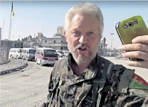  ??  ?? Michael Enright, a Manchester-born actor and YPG fighter, plays the Ariana Grande song Bang Bang on his mobile phone in Naim Square, Raqqa