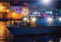  ?? Foto: Alessandro Serrano, afp ?? Das Ende eines Dramas: Die italienisc­he Küstenwach­e bringt Flüchtling­e, die von der Ocean Viking gerettet wurden, auf Lampedusa an Land.