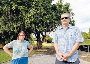  ?? TAIMY ALVAREZ/STAFF PHOTOGRAPH­ER ?? Josie Willis, left, and Oliver Buckton were among the residents of Coconut Road in Delray Beach who spoke up for a tree, seen in the background, to prevent a developer from removing it from the end of their street.