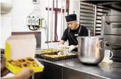  ??  ?? Chef Dennis del Rosario preparing to box up cooked egg tarts at Lord Stow’s bakery in Macau.