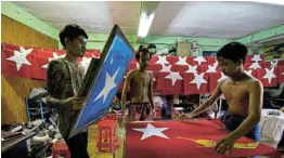  ?? Picture: REUTERS / SHWE PAW MYA ?? TRUE COLOURS: Workers print flags with the logo of Aung San Suu Kyi’s National League for Democracy NLD party at a printing house as election campaigns kick-off in Yangon, Myanmar.