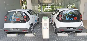  ?? (AFP) ?? Electric Blue cars being charged ahead of the launch of BlueSG office, a subsidiary of France’s Bollore Group in Singapore on Tuesday