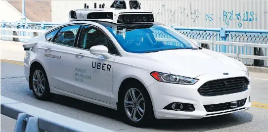  ?? JARED WICKERHAM/THE ASSOCIATED PRESS ?? A self-driving Ford Fusion hybrid model is test driven last year in Pittsburgh, Pa. Ford has set a goal of releasing an autonomous vehicle fleet by 2021.