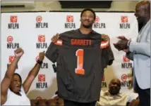  ?? NATHAN HUNSINGER - THE DALLAS MORNING NEWS VIA AP ?? Texas A&M’s Myles Garrett holds up a Cleveland Browns jersey as his mother, Audrey Garrett, left, cheers with Bruce Smith, right, after Garrett was taken as the No. 1 pick in the NFL football draft, at Terre Verde Golf Course in Arlington, Texas,...