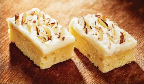  ?? PHOTOS: TOM MCCORKLE/THE WASHINGTON POST ?? A fluffy butter and cream cheese frosting is the perfect topping for these almond and ricotta bars.