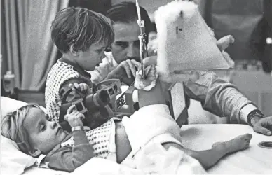  ?? DELAWARE NEWS JOURNAL FILE ?? Joe Biden visits with his sons, Beau, far left, and Hunter in their Delaware hospital room in December 1972 just days after he lost his wife, Neilia, and baby daughter, Naomi, in a car crash that left his sons badly injured.