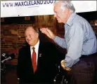  ?? AP ?? Jimmy Carter gives then-u.s. Sen. Max Cleland, D-GA., a standing ovation during Cleland’s campaign rally in Plains, Georgia, in 2002.