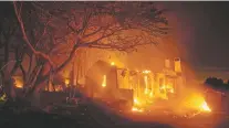  ??  ?? Flames consume a home Saturday in Goleta, Calif. The fire’s spread was stopped at about 100 acres in a neighborho­od where some houses were in ruins while homes next door were intact.