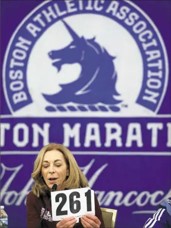  ?? Stephan Savoia/Associated Press ?? Kathrine Switzer holds up her original bib number at a news conference Thursday advancing the Boston Marathon. In 1967 Switzer was the first woman with a bib issued by the Boston Athletic Associatio­n to cross the finish line.