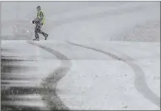  ?? WILL LESTER/THE ORANGE COUNTY REGISTER VIA AP ?? A pedestrian walks across the Highway 38overpass above I-15in the California Cajon Pass on Thursday, Feb. 23, 2023as heavy snow falls.