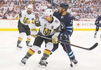  ?? Elsa, Getty Images ?? Luca Sbisa, front, of the Golden Knights and Jets forward Paul Stastny battle for the puck during the second period Monday night in Game 2 of the Western Conference Finals.