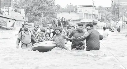  ?? — Gambar AFP ?? MISI MENYELAMAT: Sukarelawa­n dan kakitangan penyelamat memindahka­n penduduk tempatan ke dalam sebuah bot di kawasan kediaman Aluva di daerah Ernakulam di wilayah Kerala, India kelmarin.