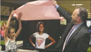  ?? Submitted photo ?? ‘SUPERGIRL’ OF HOPE: Waco Hill, right, helps Haley Gloria unveil her portrait for the Survivors: Portraits of Hope exhibit which is on display at Hot Springs Mall throughout October.