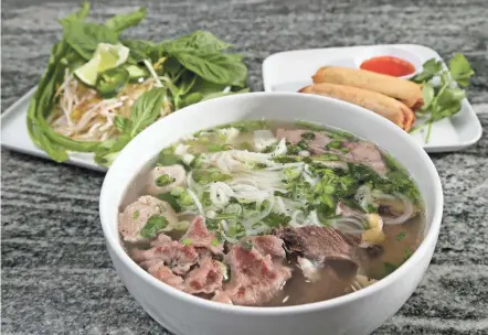  ?? PHOTOS BY BARBARA J. PERENIC/COLUMBUS DISPATCH ?? Dac Biet pho with eye of round beef, brisket, soft tendon, beef meatballs and a side of ground chicken summer rolls at Pho Le Vietnamese Cuisine on Morse Road.
