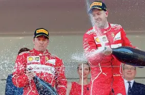  ??  ?? Sebastian Vettel (a destra) festeggia la vittoria con il compagno di scuderia Kimi Raikkonen