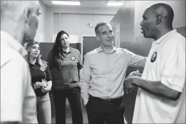  ?? Photograph­s by Kent Nishimura Los Angeles Times ?? MAYOR ERIC GARCETTI meets with First to Serve staff members during a tour of the South L.A. shelter.