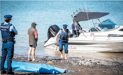  ?? Photo / Michael Craig ?? Police at Little Huia on Auckland's Manukau Harbour after the fatal boating accident.