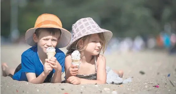  ?? Chris Loufte ?? Tristan Duncan-Sutherland, 6, and Amaia Duncan-Sutherland, 4, enjoy an icecream on Mission Bay beach, Auckland.