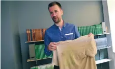  ?? FOTO: VILHELM STOCKSTAD/TT ?? Johan Gustafsson visar upp tröjan han hade på sig när han blev kidnappad i Mali.