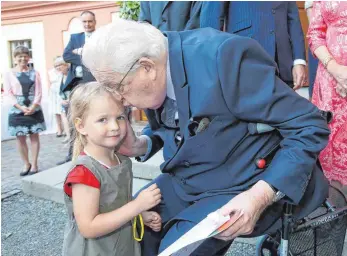  ?? FOTO: THOMAS WARNACK ?? Lara aus Altshausen schenkt Herzog Carl ein selbst gemaltes Bild zum Geburtstag. Dafür gibt es ein Küsschen für die Dreijährig­e.