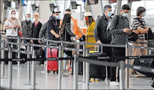  ?? Bianca De Marchi The Associated Press ?? Passengers check in at an airport Friday in Sydney. Some flights between states restarted without any COVID-19 restrictio­ns.