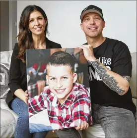  ?? KAREN SCHIELY / AKRON BEACON JOURNAL ?? Joanna Ward and Ryan Ward hold a photograph of their son James, 10, in Jackson
Twp. James went to sleep March 11, 2019 and did not wake up the next morning. His unexplaine­d death is a Sudden Unexplaine­d Death in Childhood, similar to Sudden Infant Death Syndrome (SIDS) in infants. Ryan wrote a song for his son who left a positive impression on many people’s lives. There is also a Facebook page called Smile Like James.