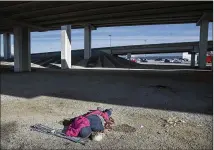  ?? RALPH BARRERA / AMERICAN-STATESMAN ?? A homeless man with crutches sleeps under the elevated portion of U.S. 290/Texas 71 last week. Austin is seeking authorizat­ion to cite and arrest homeless people in the area.