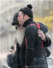  ?? MIGUEL MEDINA/AFP/GETTY IMAGES ?? Eagles of Death Metal singer Jesse Hughes, right, and guitarist Dave Catching pay tribute to the victims of the Nov. 13 Paris terrorist attacks at a makeshift memorial in front of the Bataclan concert hall on Tuesday.