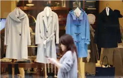 ??  ?? TOKYO: A shopper walks past a clothing shop display at a shopping street of Ginza area in Tokyo. Japan’s jobless rate fell to a 20-year low in October, but consumer spending and incomes also edged lower as the tight labor market failed to spur...