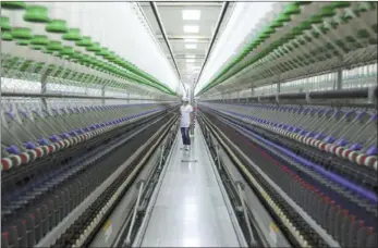  ??  ?? Worker inspects spinning quality at a Central Textiles subsidiary in Zhanjiang, Guangdong province.