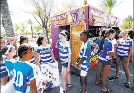  ??  ?? Members of the Next Generation Albion Soccer Club gather at their fireworks booth on Blue Diamond Road near Arville Street.