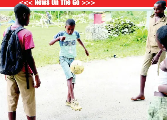  ?? IAN ALLEN ?? Big balla! Boys play football in the streets of Alderton district, St Ann.