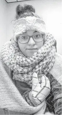  ?? Rebecca Miller / Associated Press ?? Rebecca Miller, an academic adviser at Tennessee State University, wears sweaters, a scarf, ear coverings, gloves and a blanket over her lap while she works at her desk in Holland Hall on campus in Nashville.