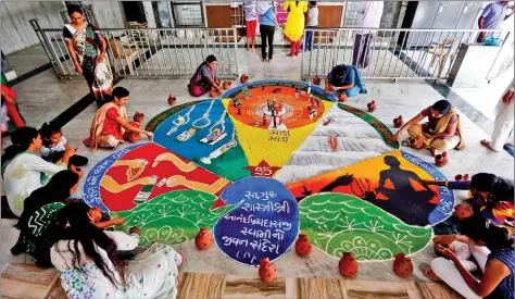  ??  ?? Women make rangoli inside a temple on the occasion of Sharad Purnima in Ahmedabad on Saturday. REUTERS