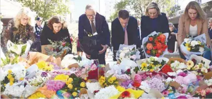  ?? REUTERSPIC ?? Albanese (third from left) and Minns join other politician­s as they lay flowers at the scene of Saturday’s mass stabbing at Bondi Junction, Sydney yesterday. –