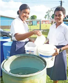  ?? ?? Jeremiah Raibevu College students, Naelani Nagone and Ledua Waqabaca fill water rations following the water cuts in Tacirua, Tamavua on April 13, 2023. Photo: