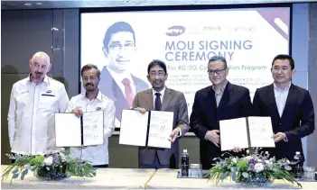  ?? Bernama photo — ?? Zahidi (middle) witnesses the deal signing between MRH Digital, Chengdu Sihan and Cosmos Internatio­nal Consultanc­y Sdn Bhd. Present are (from left) MRH Digital project director David James Higiat, Rohaizee, Liu Jian and Woo.