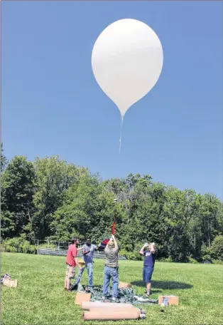  ?? AP PHOTO ?? In this Wednesday, Aug. 9, 2017, photo, an 8-foot balloon carrying a camera rises into the sky during a test launch at the University of Hartford in West Hartford, Conn. A team from the University of Bridgeport and the University of Hartford conducted...