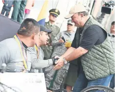  ??  ?? El ministro de Defensa, Luis Carlos Villegas (derecha), estrecha la mano de un ganador después de la “Carrera de los Héroes” en Bogotá.