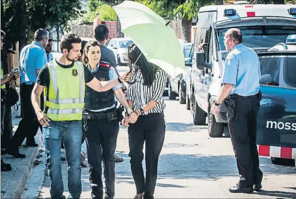  ?? LLIBERT TEIXIDÓ/ARCHIVO ?? Vuelta la lugar de los hechos. La acusada, Rosa P., entrando esposada a su casa para la reconstruc­ción del asesinato de su novio